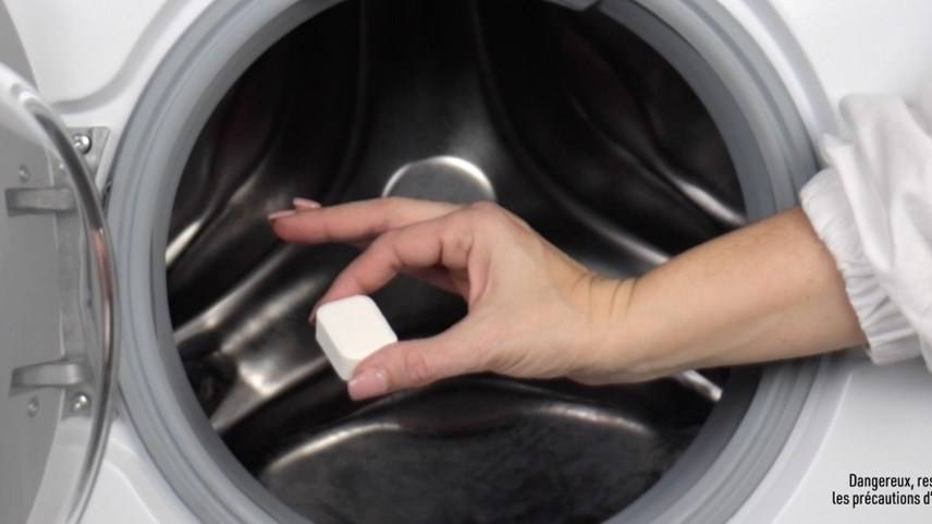 Insertion d’une tablette Vanish oxi action booster de lavage dans une machine à laver